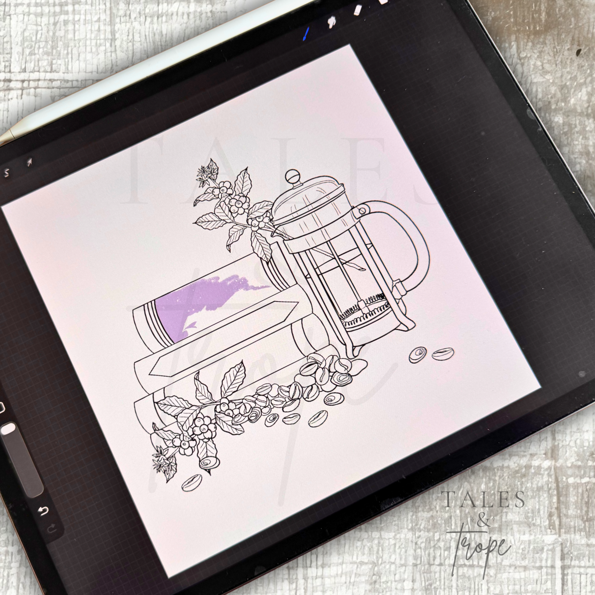 A tablet screen displays a digital coloring page design featuring a French press, books, coffee beans, and floral elements in black outlines with a purple splash accent. The tablet rests on a light gray textured surface with a stylus nearby.